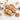 Gingerbread cookies pressed with man, woman and house designs on a gold plate beside metal stamps