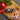 Taylor folding thermometer on a cutting board with tomato, onion and peppercorns