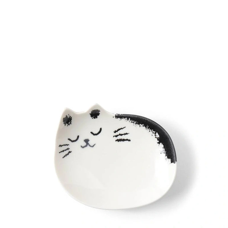 Cat-head-shaped white sauce dish with a sleeping black and white cat