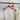 Two red (re) hangers holding a shirt and trousers on a rail
