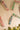 Paper Christmas crackers strung on thread against a light wall