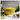 Yellow oven with lid on a marble board with lemons, scallions and a wine glass