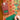 Hand writing on a green gift tag beside wrapped presents