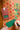 Hand writing on a green gift tag beside wrapped presents