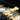 Tweezer tongs turning chicken skewers on a grill