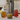 Nitro infuser with steel canister and gray base beside nitro cold brew and colorful drinks