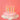 Pastel twirl candles lit on a pink frosted cake