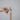 Hand holding the duck candle snuffer, lowering its bell over a lit taper