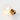 Softly glowing filament lightbulb with gold base lying on a white surface