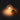 Glowing filament lightbulb with gold base lying on its side against a dark background