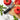 OXO serrated peeler on marble beside tomatoes, basil and a cutting board