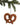 Brown felt pretzel ornament with white stitched dots hanging from a pine branch
