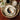 Table setting with floral arrangement, coffee cup, and decorative plates on a wooden table.