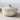 Le Creuset 9-quart round Dutch oven with a vibrant enamel exterior and sturdy lid, ideal for slow cooking and baking.