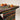 Multicolored woven table runner on a wooden table with persimmons.
