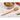 Olive wood cooking spoon standing handle down in a countertop utensil crock