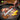 GEFU BBQ Tongs in use over charcoal grill