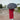 Person in a red coat holding the open black Meowmbrella on a rainy street