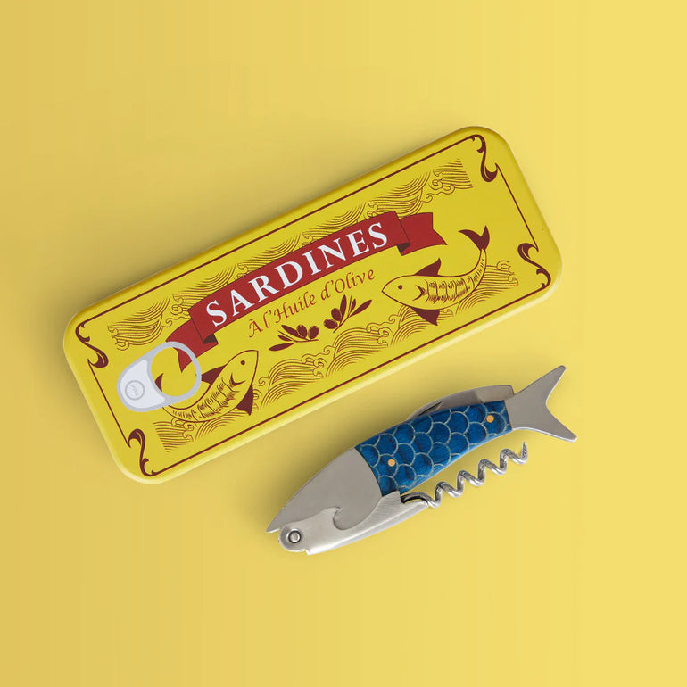 Balvi blue sardine shaped corkscrew standing beside its yellow tin case