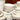 Stack of Fish's Eddy Greenband cream stoneware dinnerware — mugs, bowls, and plates with green band detail — arranged on a wooden surface against a rustic wood backdrop