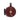 Le Creuset Rhone whistling tea kettle with a glossy red finish and stainless steel handle on a stovetop.