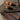 Colorful woven placemats with persimmons on a wooden surface