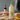 Now Designs Olive Oil cruet on a wooden table with bread and a bottle of wine