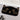 Black cat doormat on a gray floor in front of a white door, beside a pair of sneakers