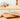 Olivewood spoon resting on a wooden cutting board on a kitchen counter