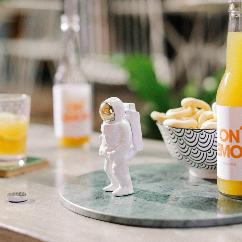 Doiy astronaut-shaped bottle opener in white with a gold visor.