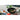 Le Creuset 12-inch anodized stir fry pan with black handle, shown with stir-fried vegetables in the pan.