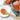 Olivewood spoon with tomato sauce on a plate beside a saucepan