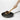 Straight edge of the OXO wooden paddle scraping the corner of a pan