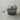 Le Creuset 1.75-quart iron handle sauce pan with a black handle and stainless steel lid on a stovetop.